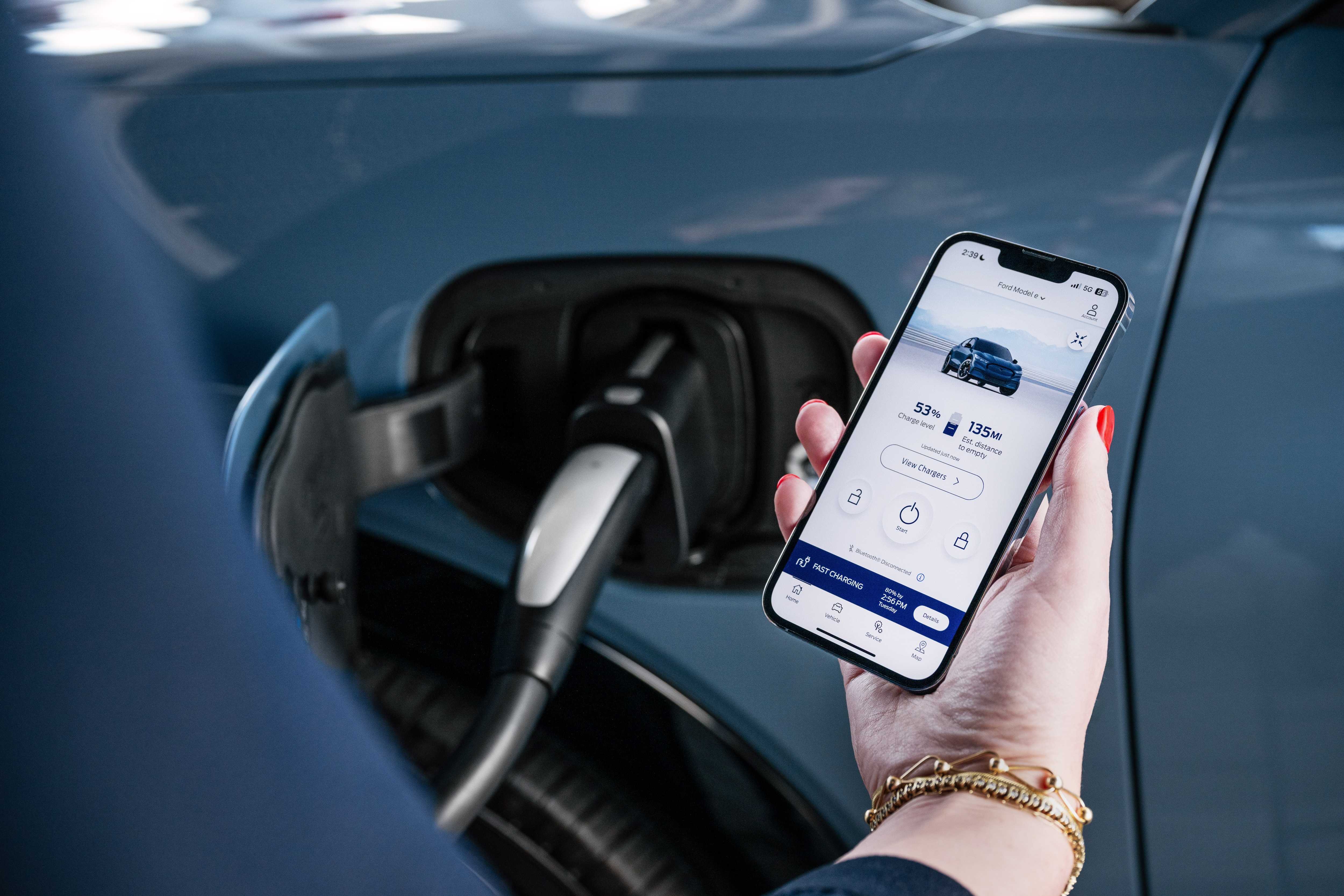 A woman reviews the charging status of her vehicle on the FordPass app.